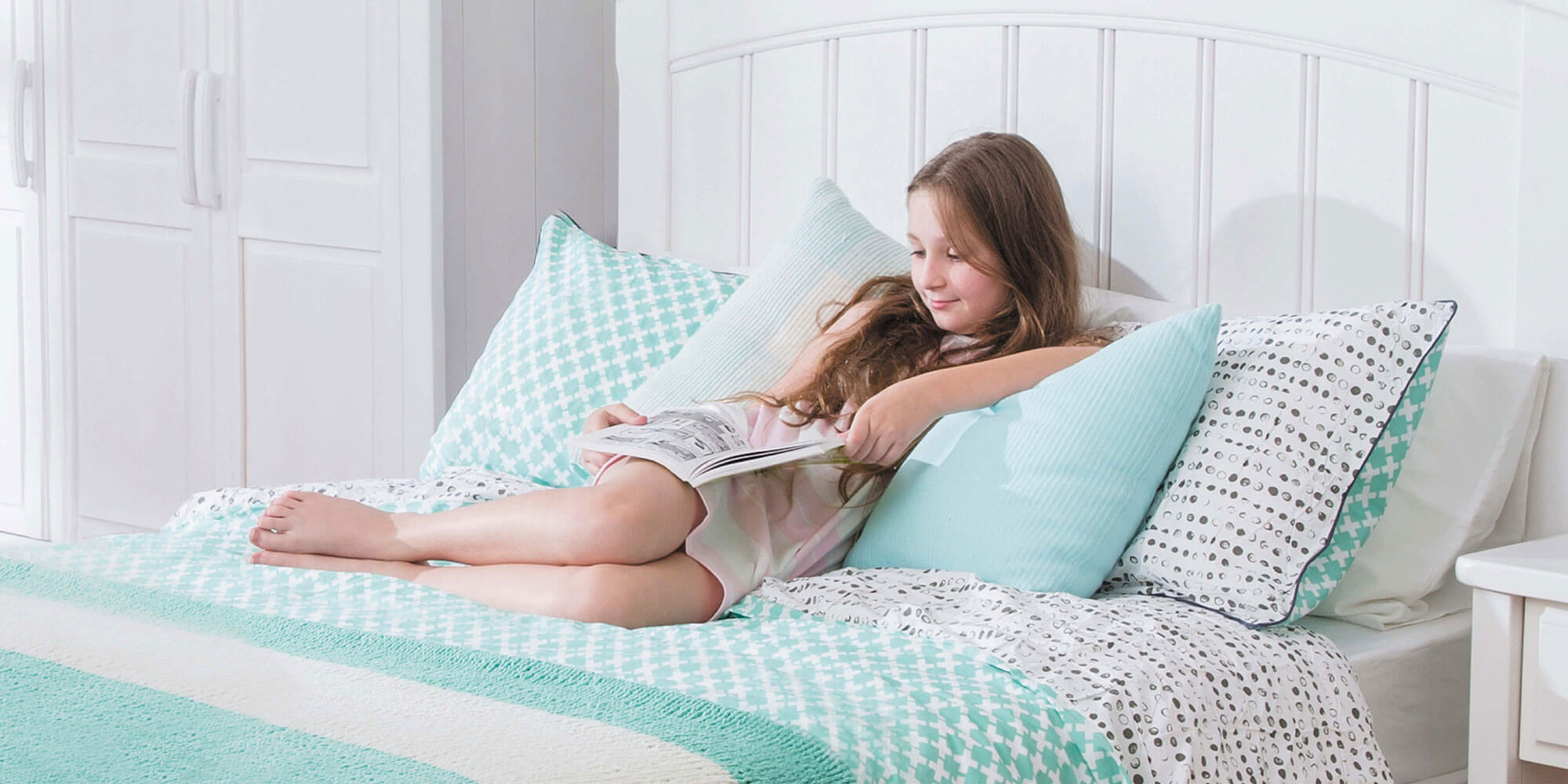 Teen girl reading in bed