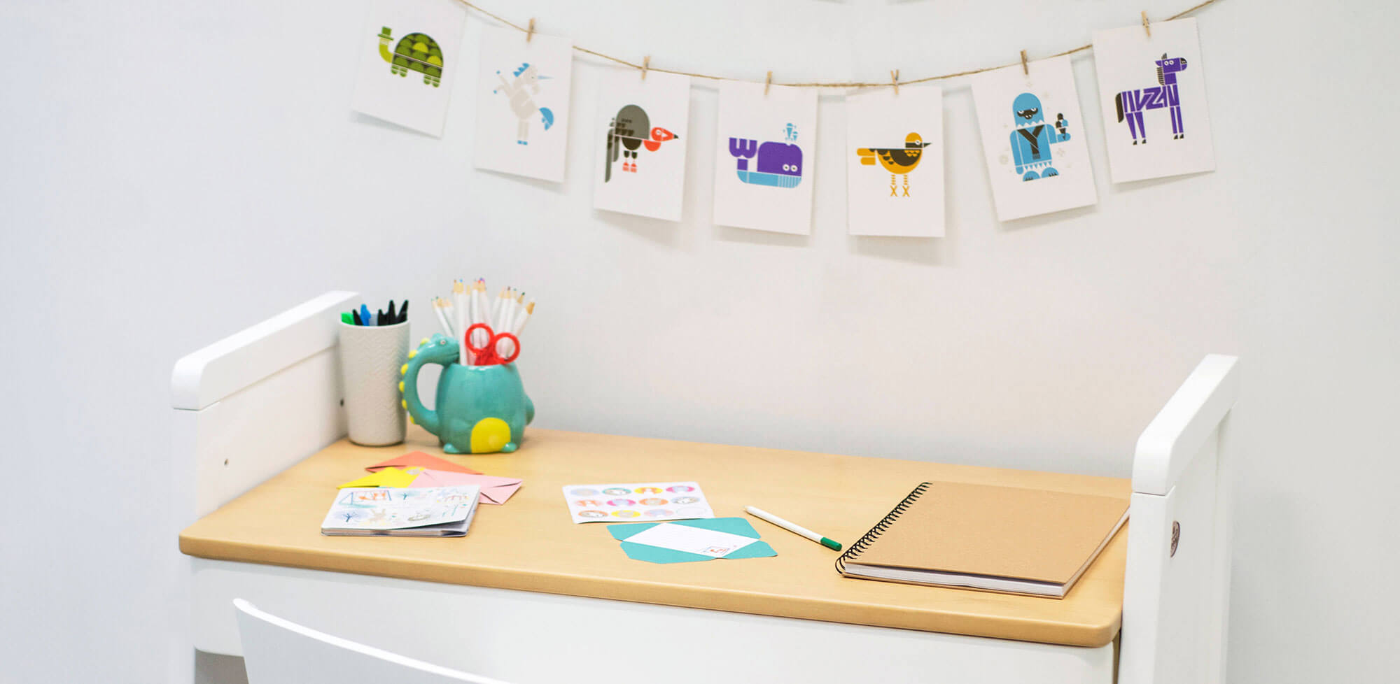 Children's desk set up with colour postcard bunting