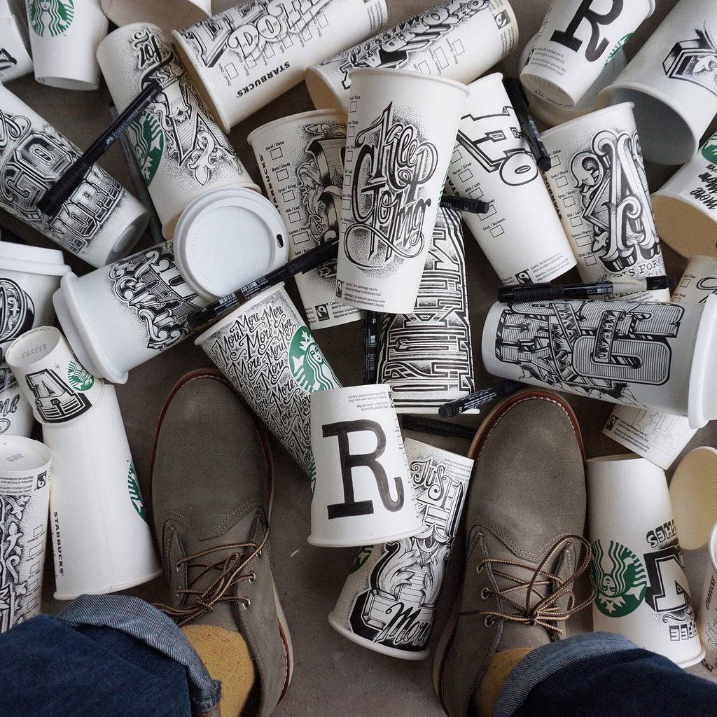 Coffee cups on the floor with each one illustrated by Rob Draper from @RobDraper1 on Instagram