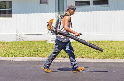 person mowing leaves