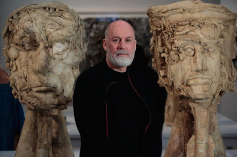 Portrait of Jean-Pierre Larocque between two of the artist's large sculptures.