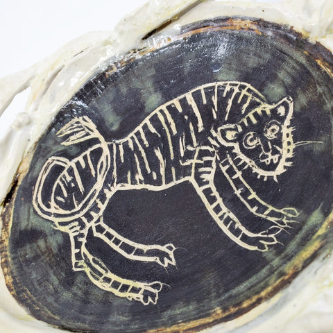 Medium-large oval platter with a tiger carved into the glaze.