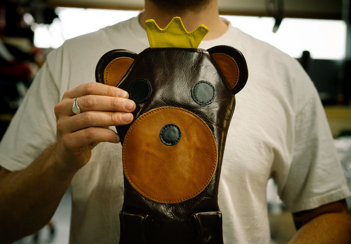 Photo of a fully-assembled custom club head cover being held up by a craftsperson