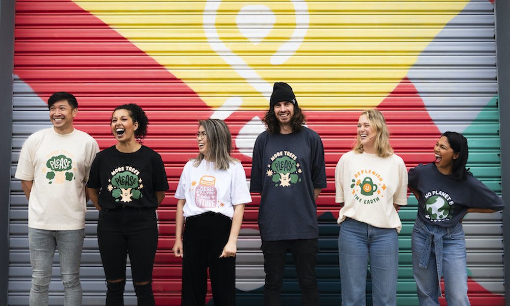 diverse young adults wearing ethical shirts with cute illustrations in front of colourful wall