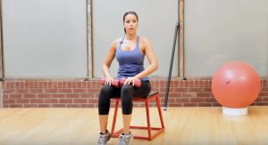 woman on red metal stool doing heel raises to help with pain from shin splints