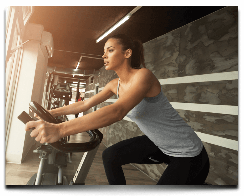 training.  woman on a stationary bike warming up for her main workout activity