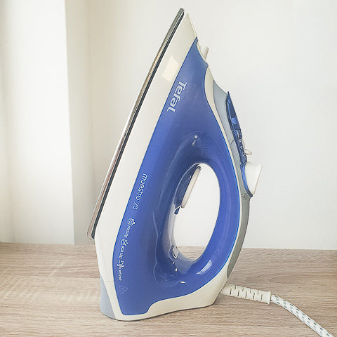 A blue and white iron sitting on a table