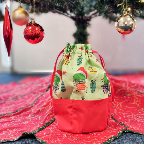 A fabric gift bag sat under a christmas tree