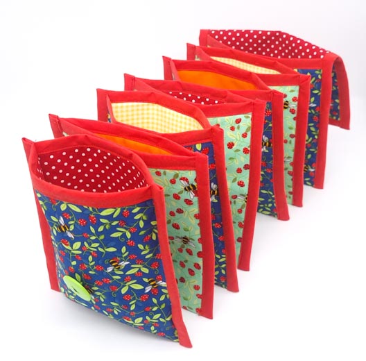 A concertina fabric wallet in bright colours with strawberries and bees