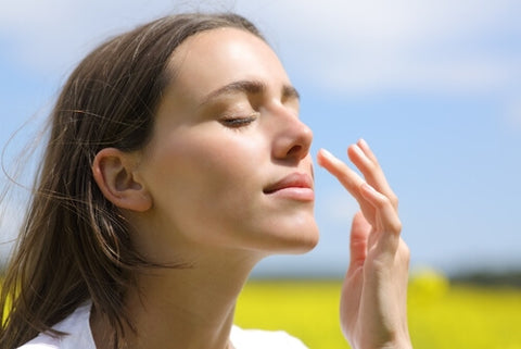 a women using sunscreen on her dry skin in open field