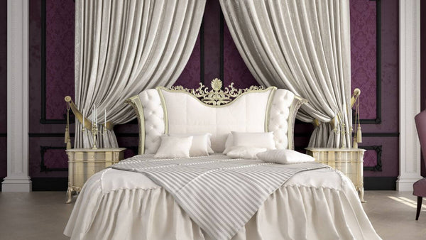 a royal looking bed with candles beside it