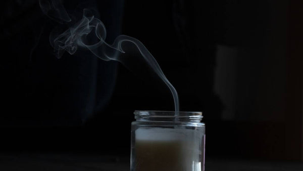 a plume of smoke coming form an extinguished candle