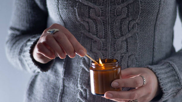 a woman lighting a candle with a match