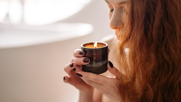 a woman smelling a candle