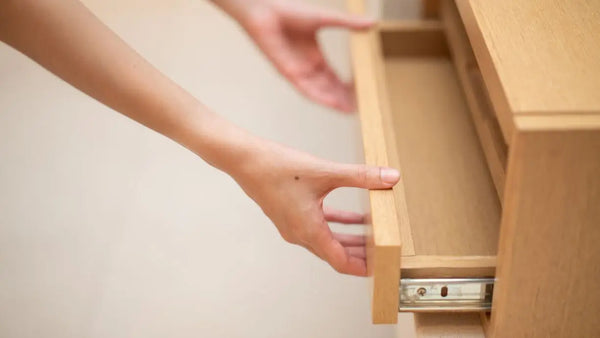 a person opening a drawer for storage