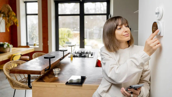 a woman adjusting the temperature in the room