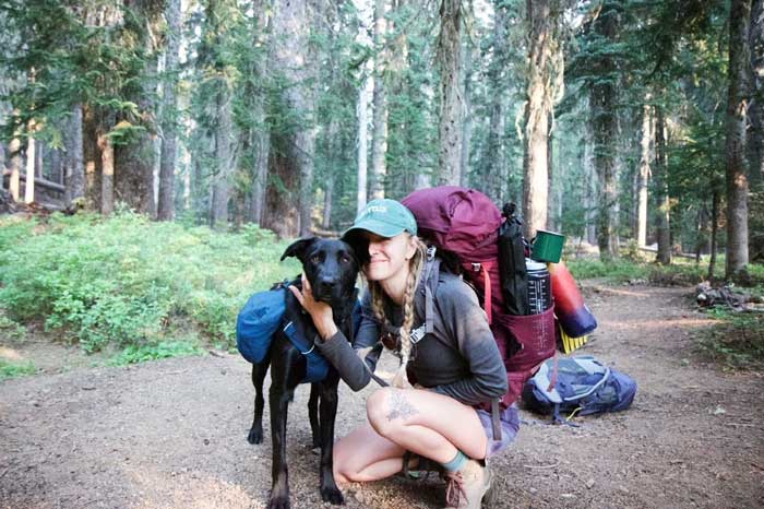 backpacker on trail with dog