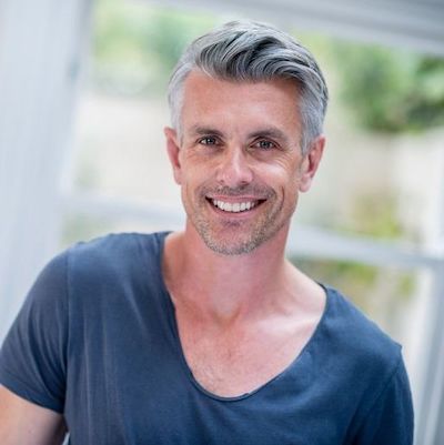 Picture of middle aged man with full head of grey hair, for our blog post on Nutrafol Products for Thinning Hair in Men
