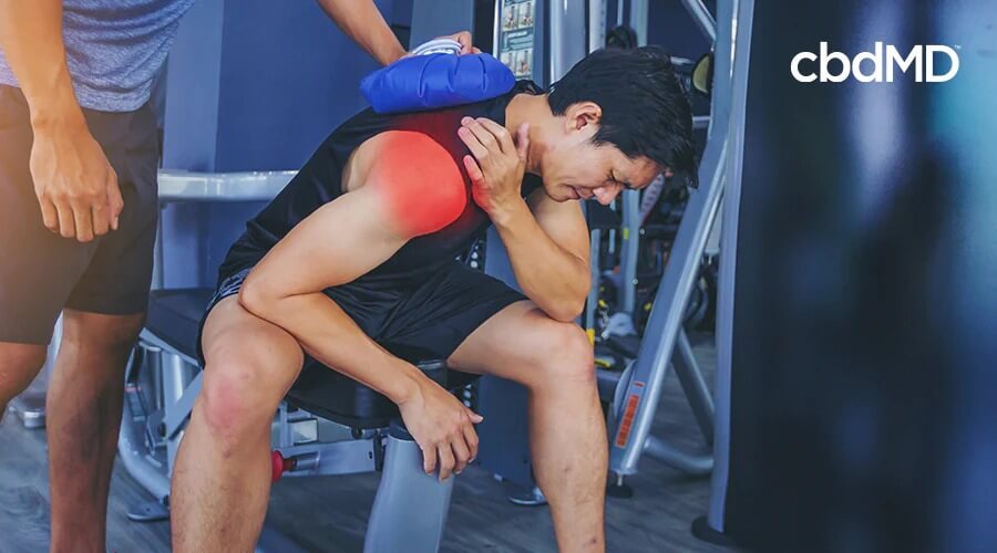 Hombre con hielo en el hombro con dolor intenso después de hacer ejercicio