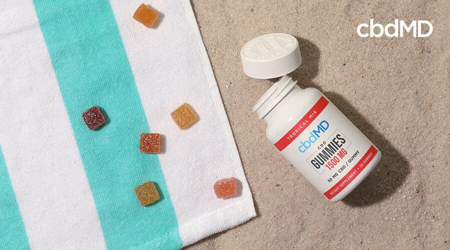 cbdMD 1500 mg gomitas de CBD en la playa con toalla a rayas