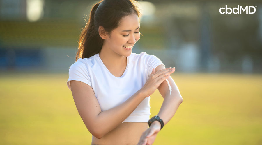 Atleta aplicando creme CBD para recuperação muscular