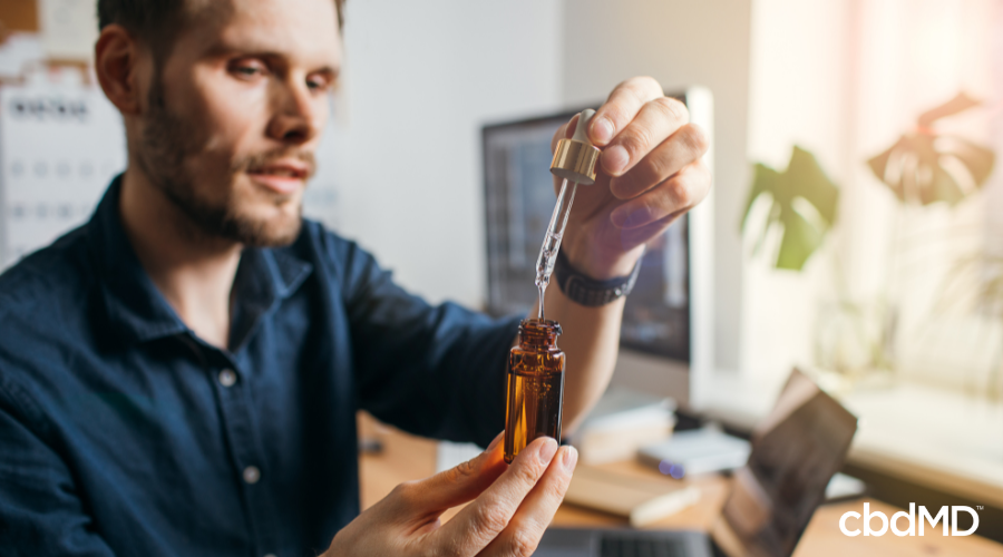 Man Taking Broad Spectrum CBD Tincture at Work