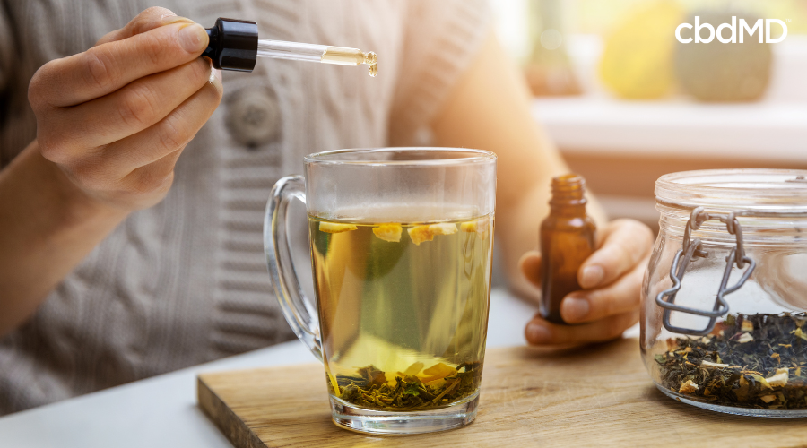 Person Adding CBD Tincture to Tea