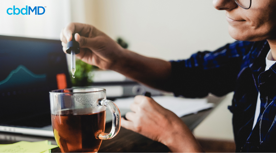 Person Adding CBD Tincture to Tea for Focus