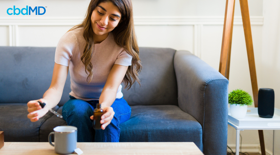 Woman Adding cbdMD CBD Tincture to Tea for Self Care