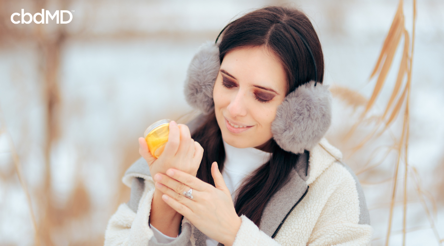Woman Applying CBD Cream to Dry Skin from Winter