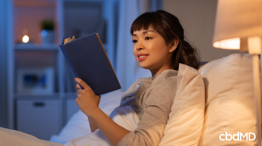 Woman Reading in Bed and Relaxing to Go to Sleep