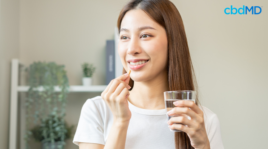 Woman Taking CBD Capsule from cbdMD