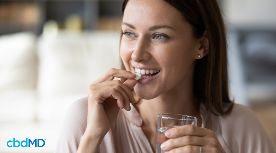 Woman Taking cbdMD Tablet for CBD Pain Relief