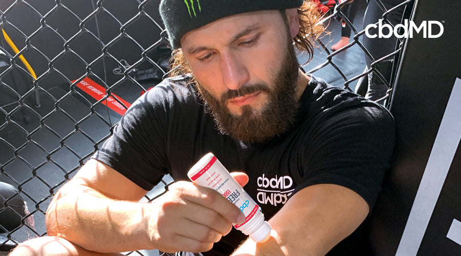 Jorge Masvidal aplica rolo cbdMD CBD Freeze 1500 mg em seu braço