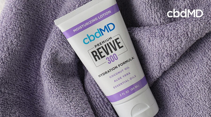 A tube of 300 mg cbd revive from cbdmd sits on a folded towel