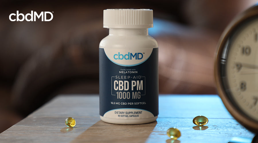 A bottle of 1000 mg cbd pm capsules sits on a night stand