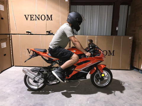 Venom x18 50cc with rider 6 foot standing next to motorcycle venom x18 size