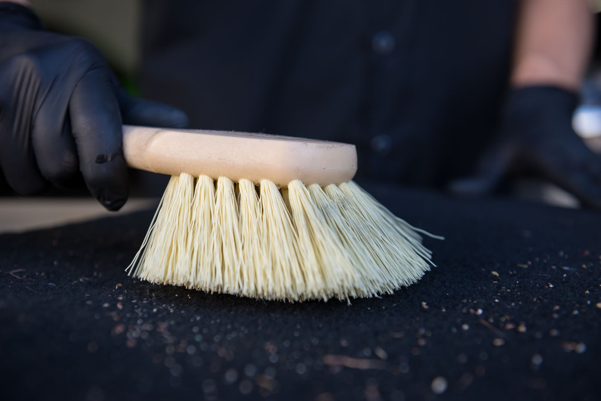 Brushing the Heavy Duty Nifty Interior Detailing Brush against a carpet floor mat