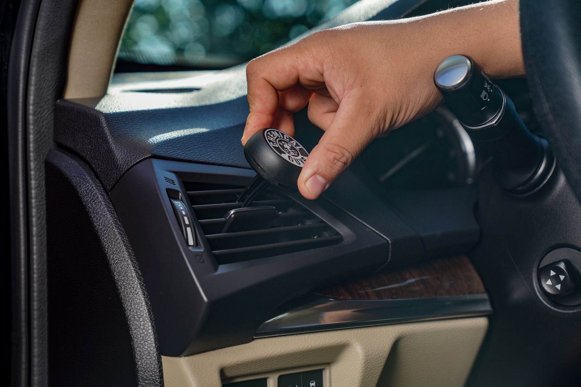 Clipping a Chemical Guys Vent Clip Air Freshener to the dashboard AC vent.