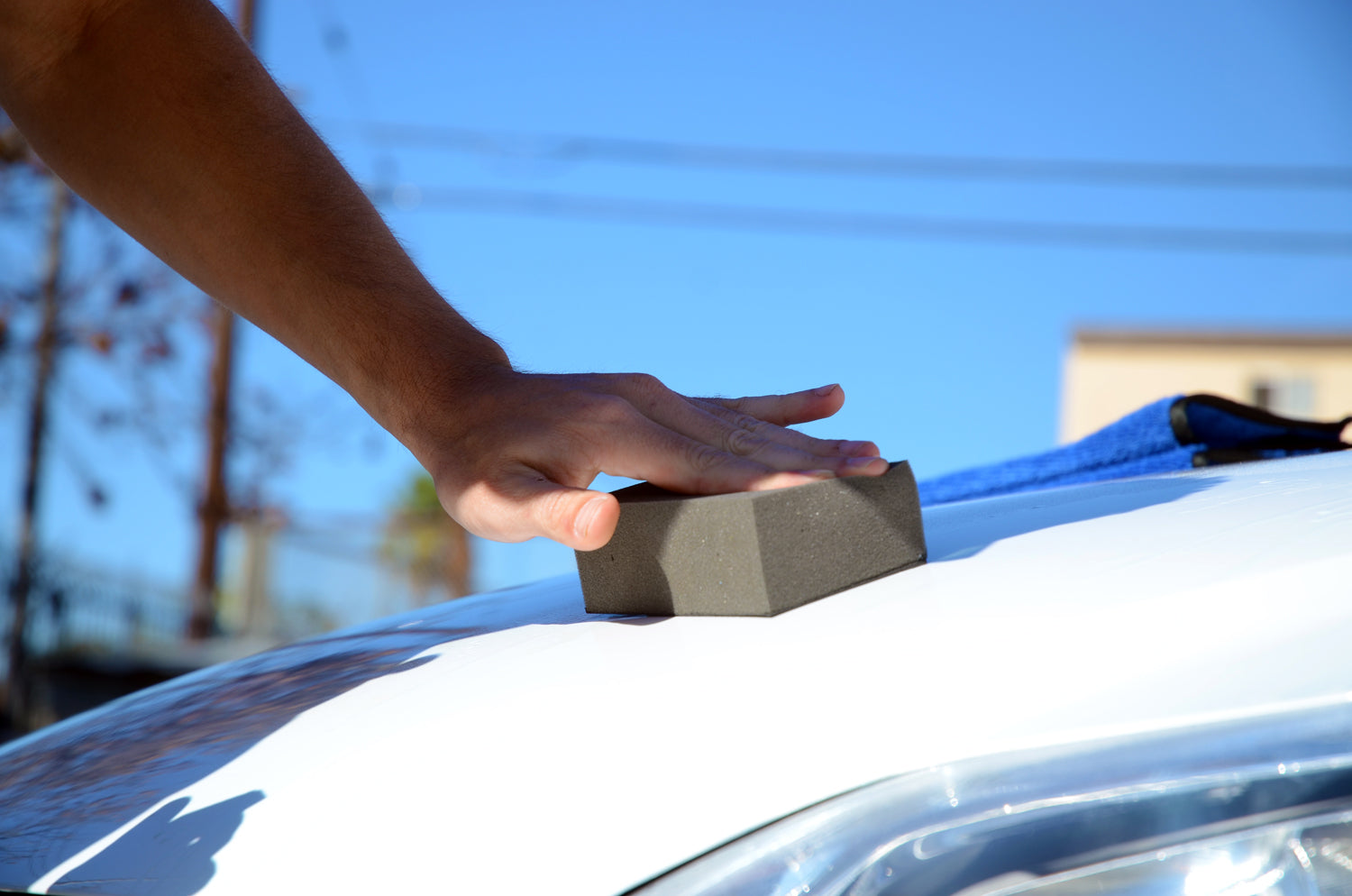 Decontaminating a white car exterior with the Clay Block