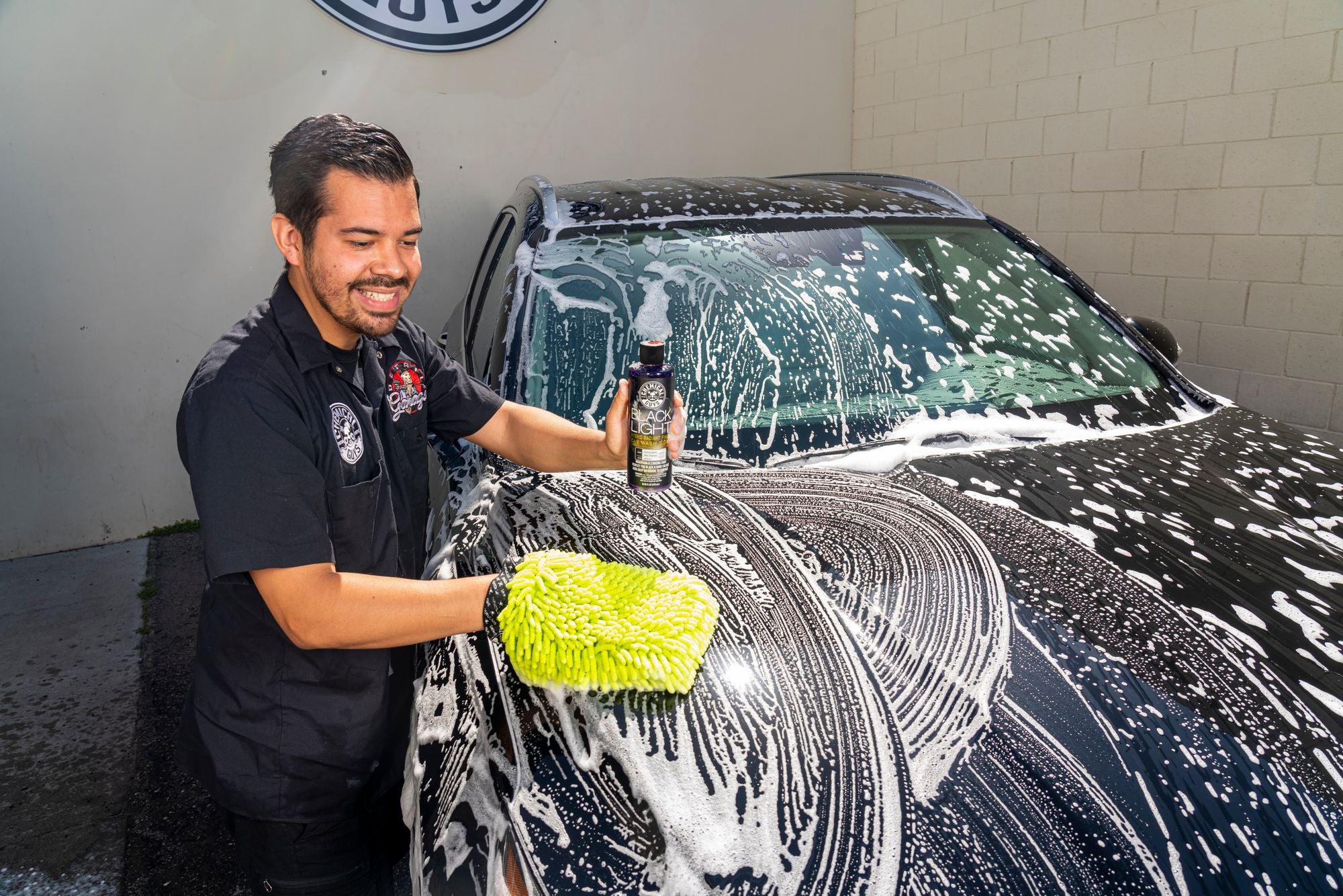 Washing a black car with Black Light Car Wash Soap and a chenille wash mitt.