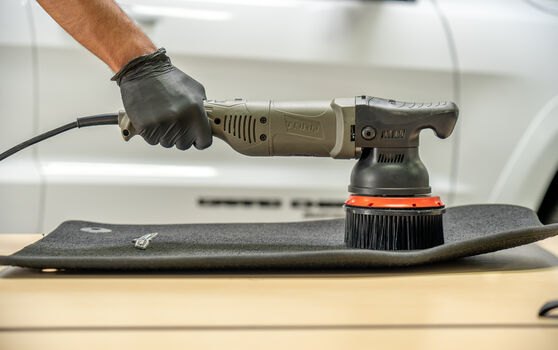 A DA Machine Cleaning a Car Mat