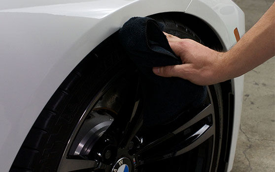 Wiping Down a Car Tire with a Microfiber Towel