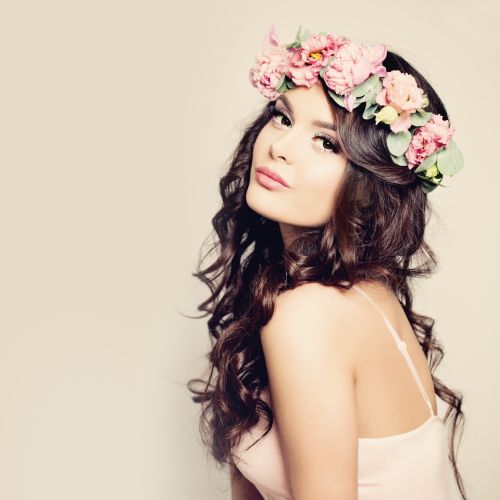 Woman with Healthy Curly Hair and Flowers