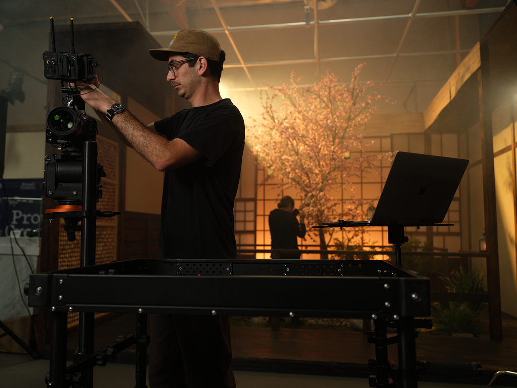 A man is configuring a cinema camera mounted to an INOVATIV Camera Mount System.