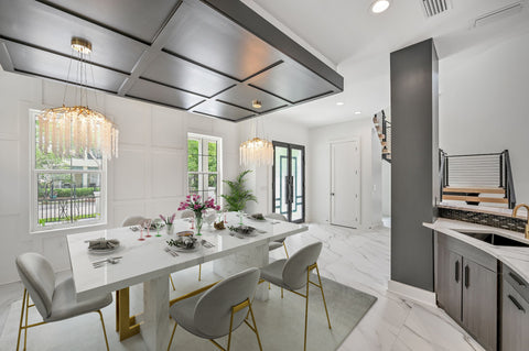 A Virtually staged dining room with a modern white table, white and gold chairs and tasteful place settings