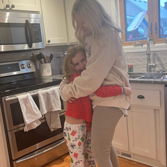 Mom and daughter hugging in the kitchen.