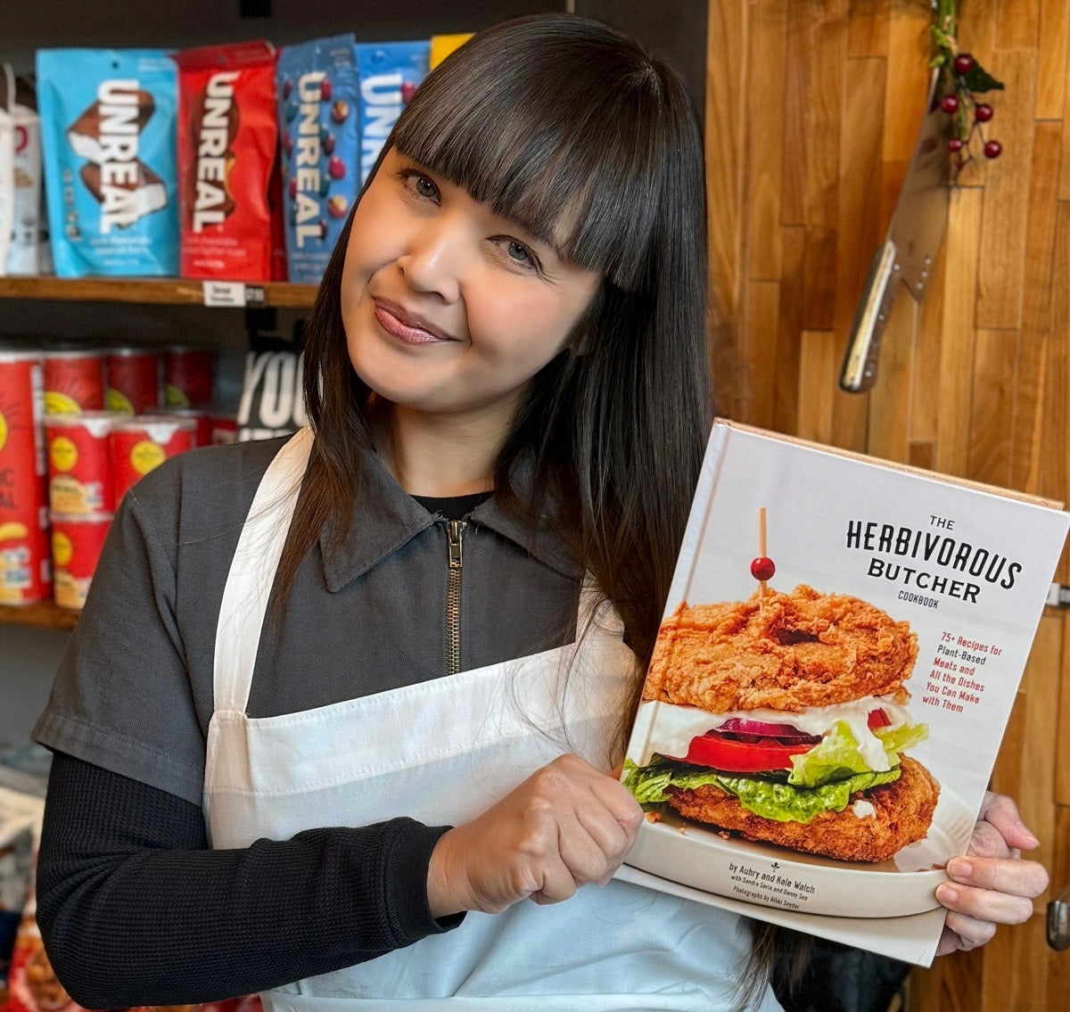 Aubry Walch holding a copy of The Herbivorous Butcher Cookbook