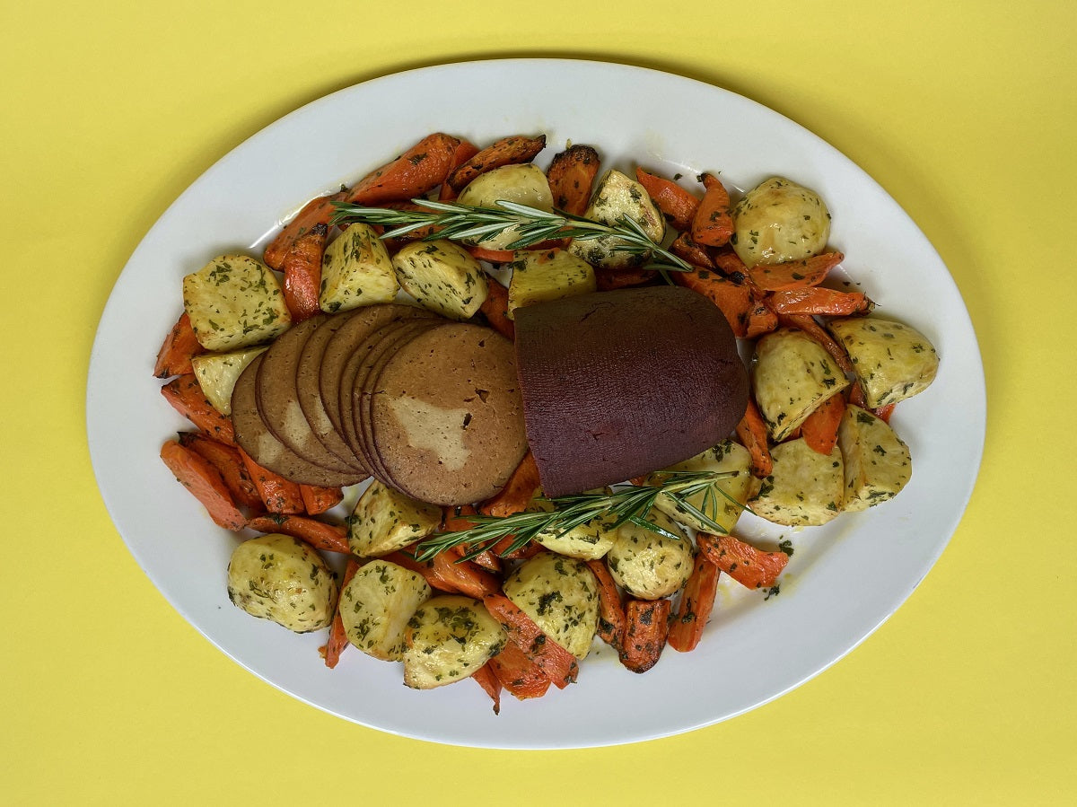 vegan ham roast with roasted potatoes and veggies