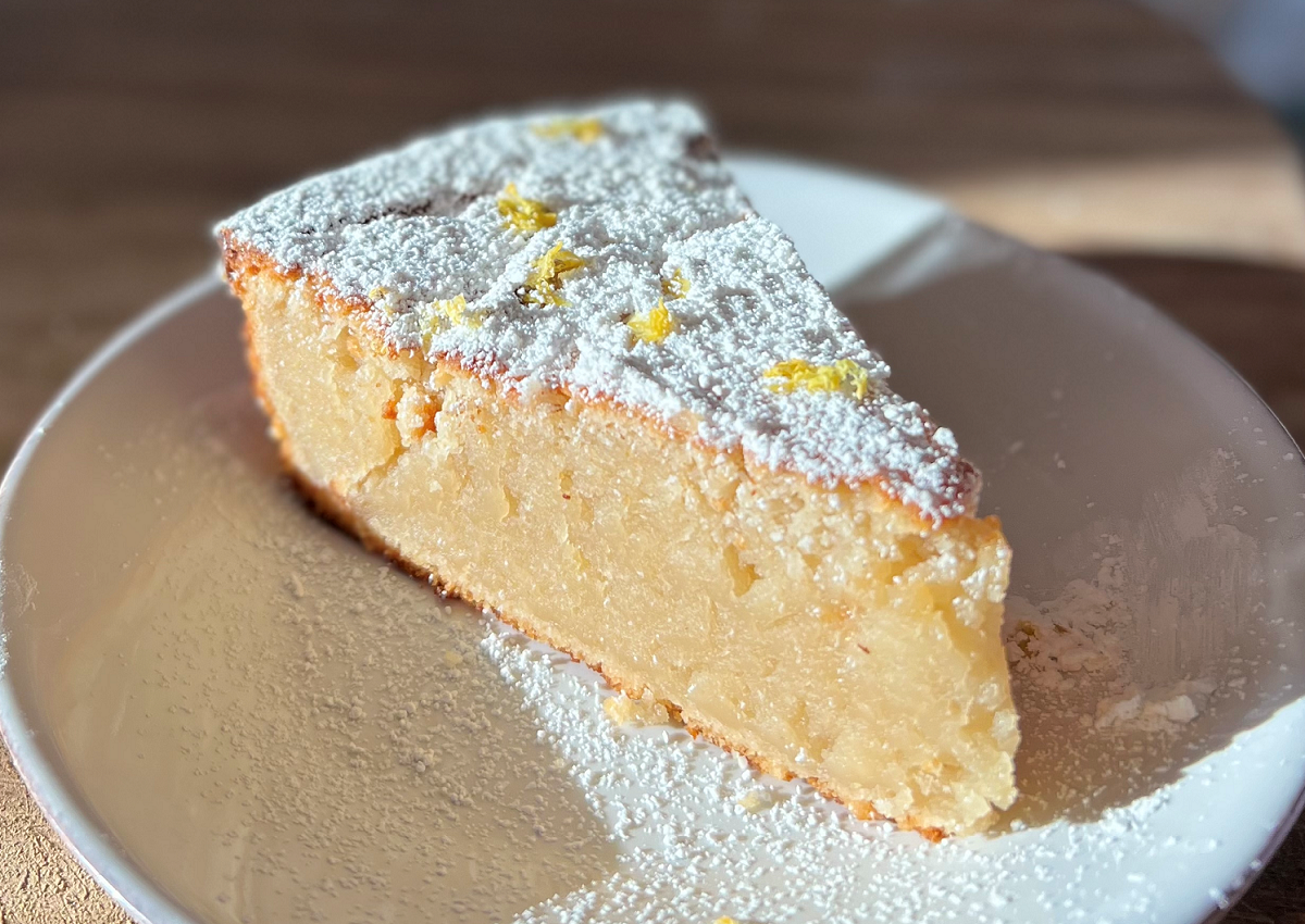 one slice of vegan dairy free lemon ricotta cake dusted with powdered sugar